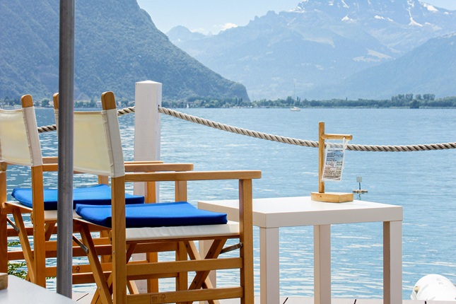 chair overlooking geneva lake with mountains in background